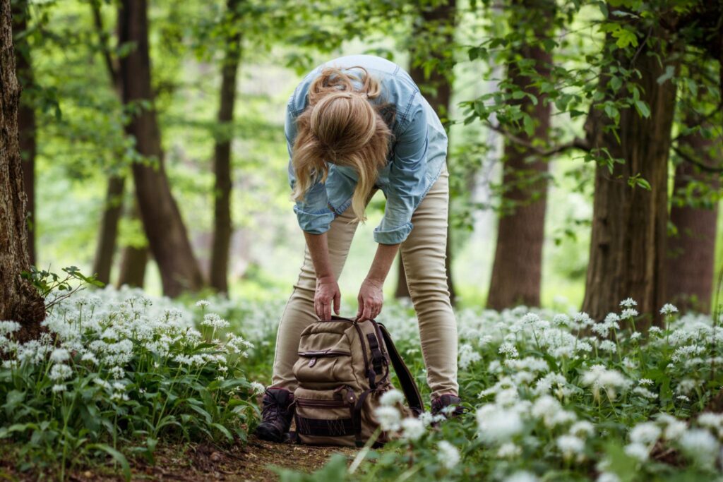 Personne déposant un sac lourd, symbole du besoin de relâcher la pression et le perfectionnisme.